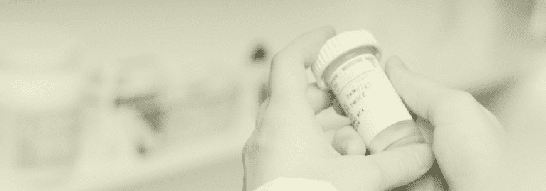 Close-up of a Clinical Pharmacist holding a prescription bottle, ensuring safe medication management in primary care. Vela Medical Group connects pharmacists with top locum and permanent roles in the UK.