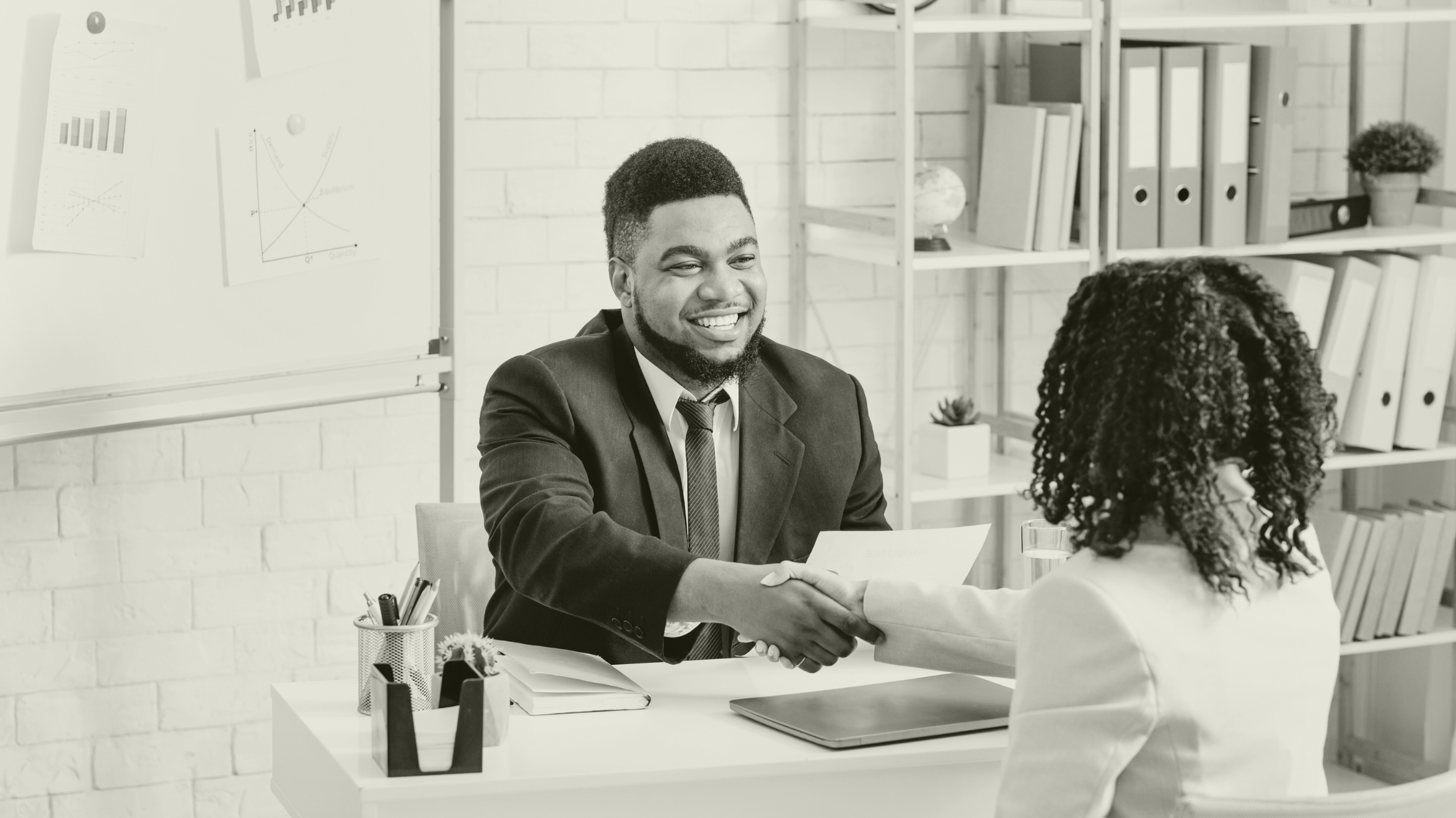 Recruiter and healthcare professional shaking hands during a positive meeting, representing trusted partnerships in primary care recruitment.