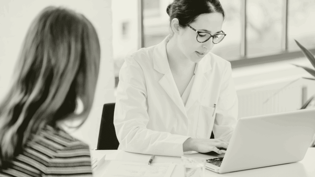 Locum GP reviewing patient notes during a consultation, supporting continuity of care in a primary care setting
