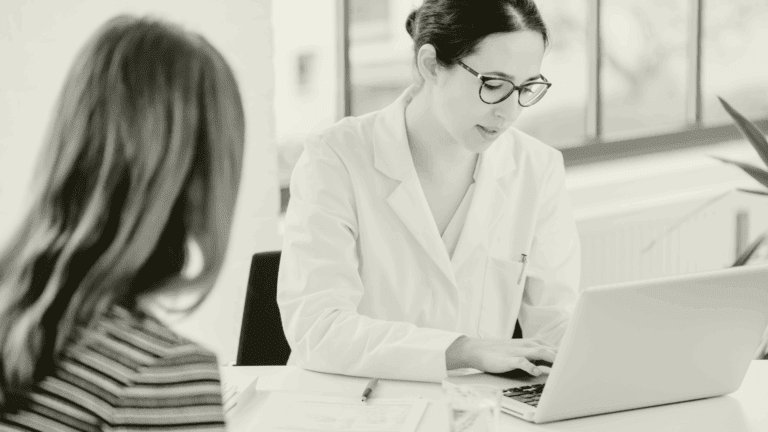 Locum GP reviewing patient notes during a consultation, supporting continuity of care in a primary care setting