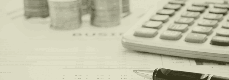 Close-up of calculator, pen, and stacked coins on a cost breakdown sheet, representing recruitment savings in Primary Care