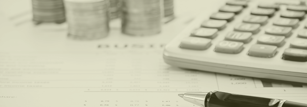 Close-up of calculator, pen, and stacked coins on a cost breakdown sheet, representing recruitment savings in Primary Care