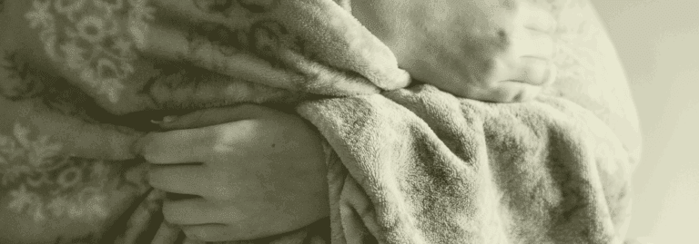 Hands holding a blanket symbolising winter pressures in healthcare, representing the need for proactive primary care staffing support with Vela Medical Group.