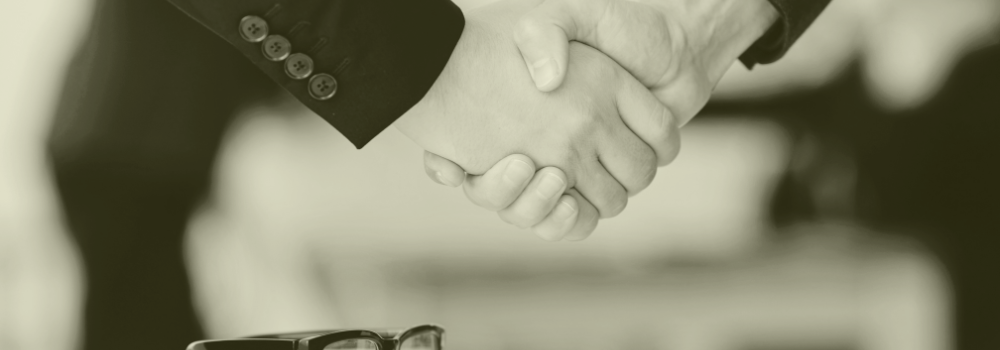 Close-up handshake symbolising trust, partnership, and transparent primary care recruitment with Vela Medical Group.