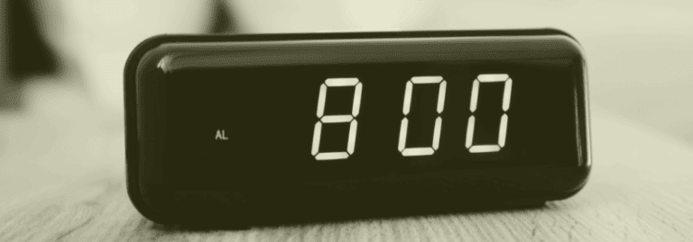A digital alarm clock displaying 8:00, symbolising the traditional 8am GP appointment scramble and Scotland’s move towards flexible walk-in hubs in primary care.