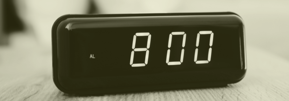 A digital alarm clock displaying 8:00, symbolising the traditional 8am GP appointment scramble and Scotland’s move towards flexible walk-in hubs in primary care.