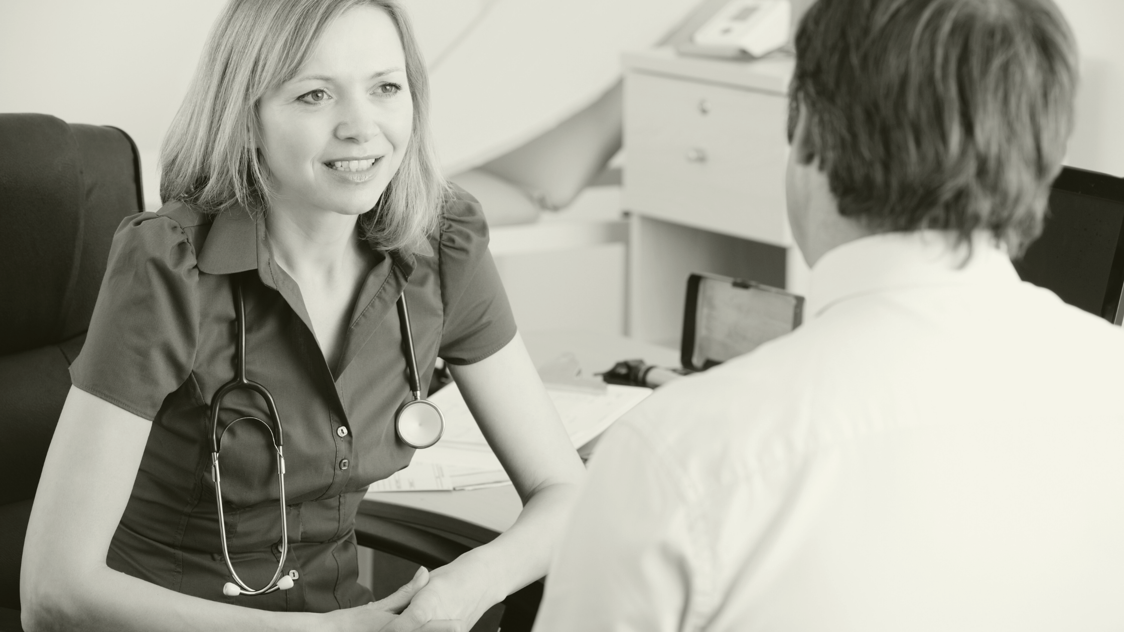 Female GP discussing patient care with a colleague in a primary care consultation, representing collaboration in general practice recruitment.