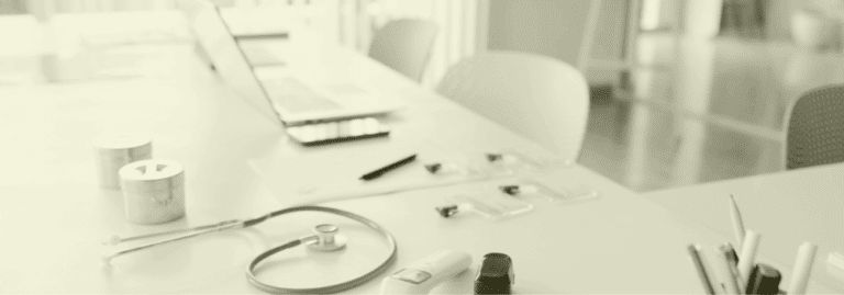 A stethoscope, laptop, and medical equipment on a desk symbolising planning, recruitment, and strategic workforce development in primary care for 2026 and beyond.